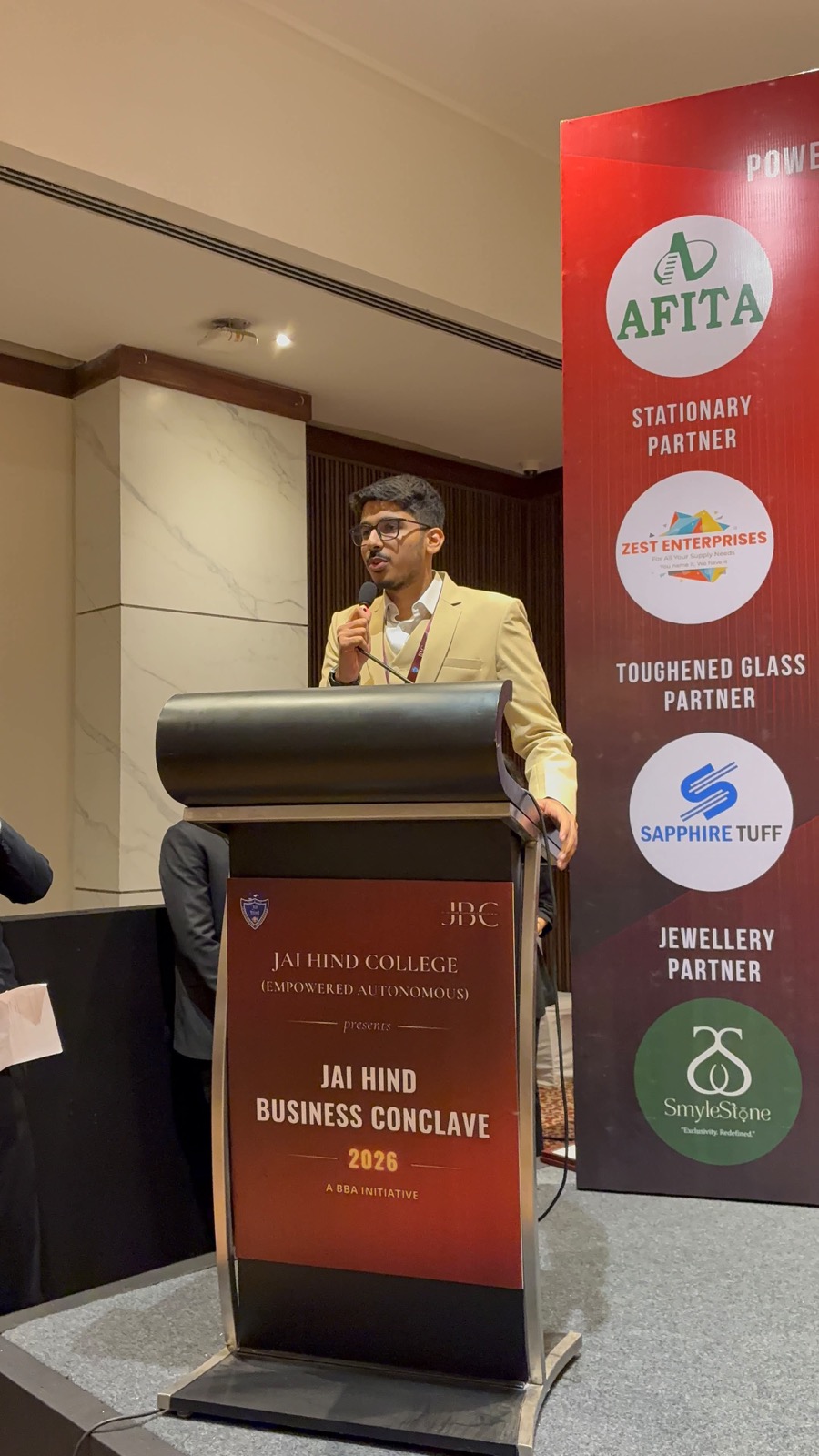 Hamza speaking at the lectern during Jai Hind Business Conclave 2026
